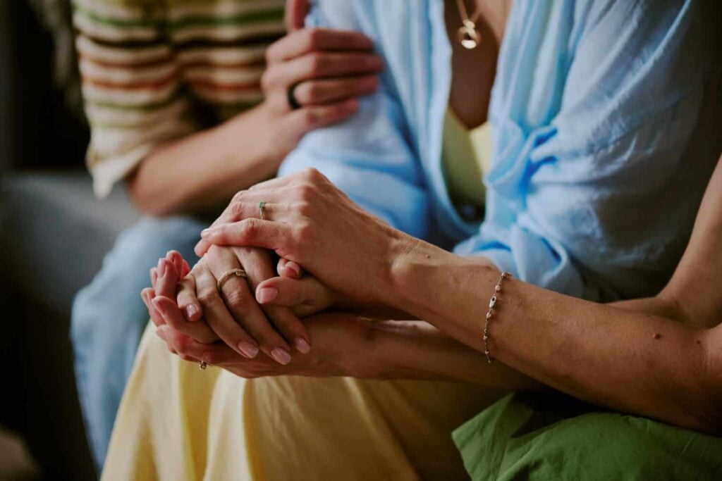 close shot of womens hands holding-each other, concept of support and healthy relationships