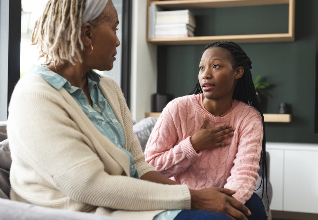 mother and teen daughter talking seriously in an indoor setting