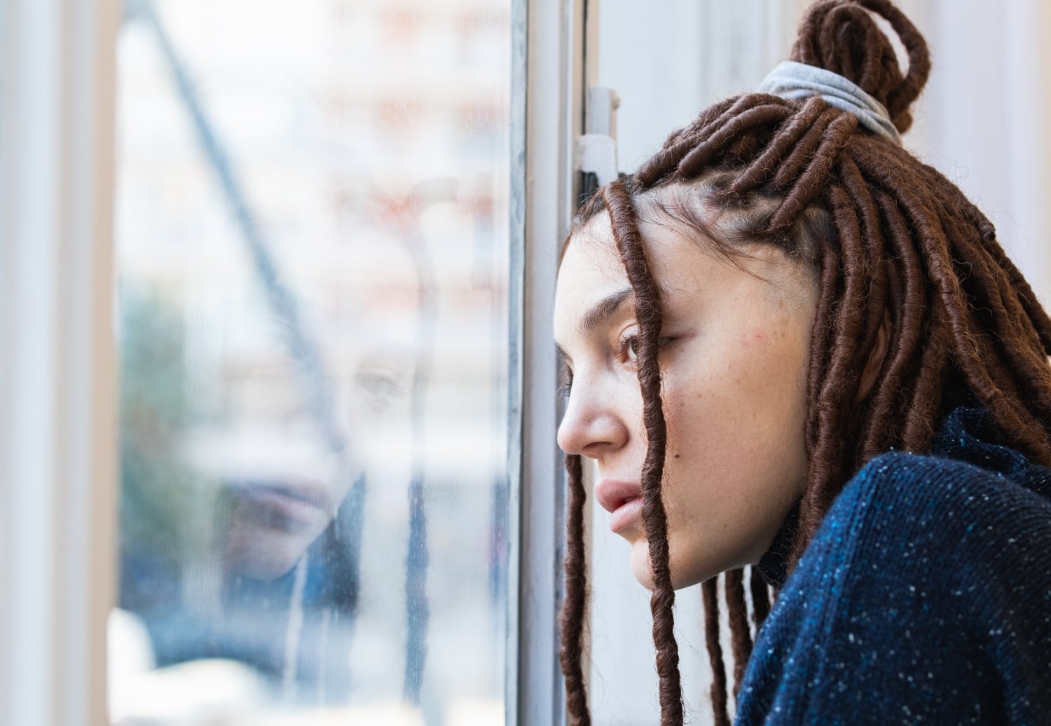 young woman gazing out the window, concept of mental health, isolation, depression